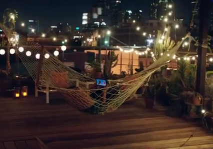 Amazon TV ad shows Kindle in a hammock on a city deck